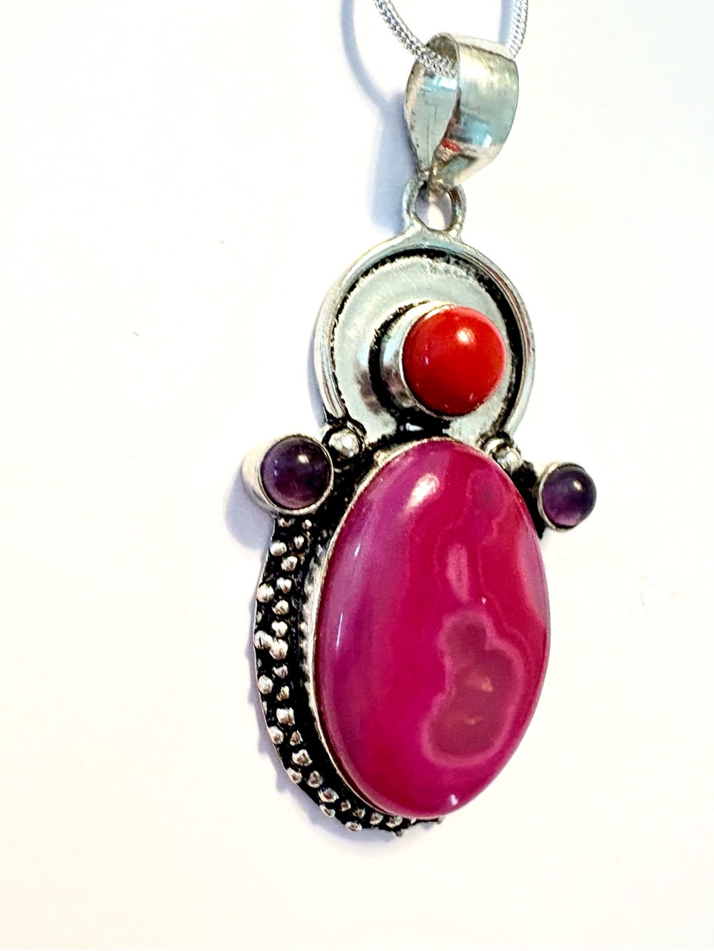 2 inch, 925 marked, Solar Agate, Amethyst, and coral pendant on a silver chain.